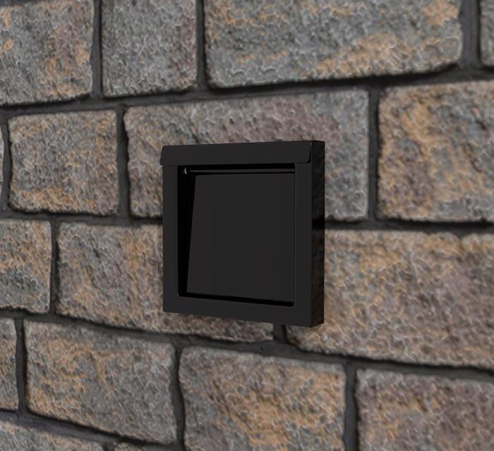 DryerWallVent in black installed in a stone wall.