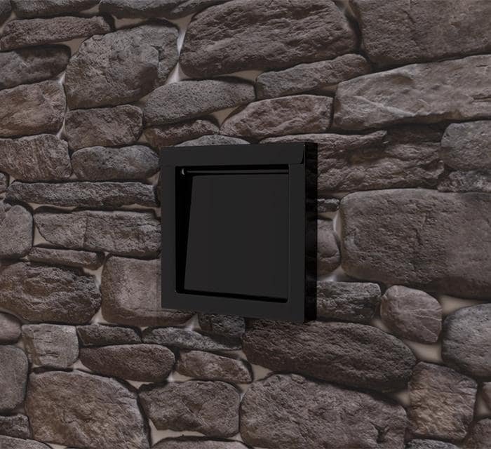 DryerWallVent in black installed in a stone wall.