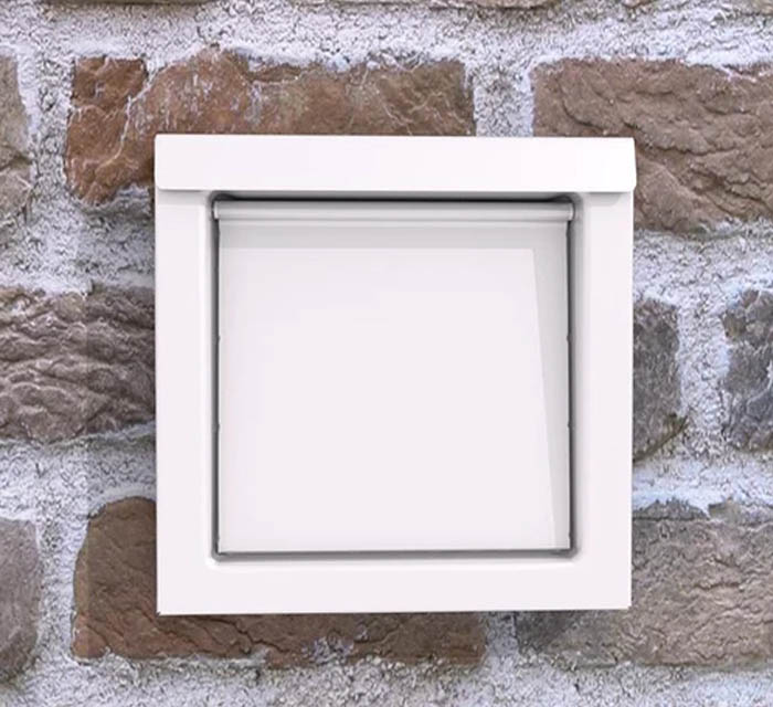 DryerWallVent in white installed in a stone wall.