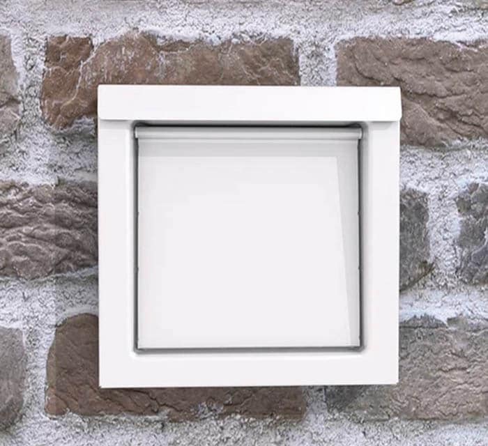 DryerWallVent in white installed in a stone wall.